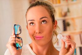 Mujer con lentes de contacto en su mano